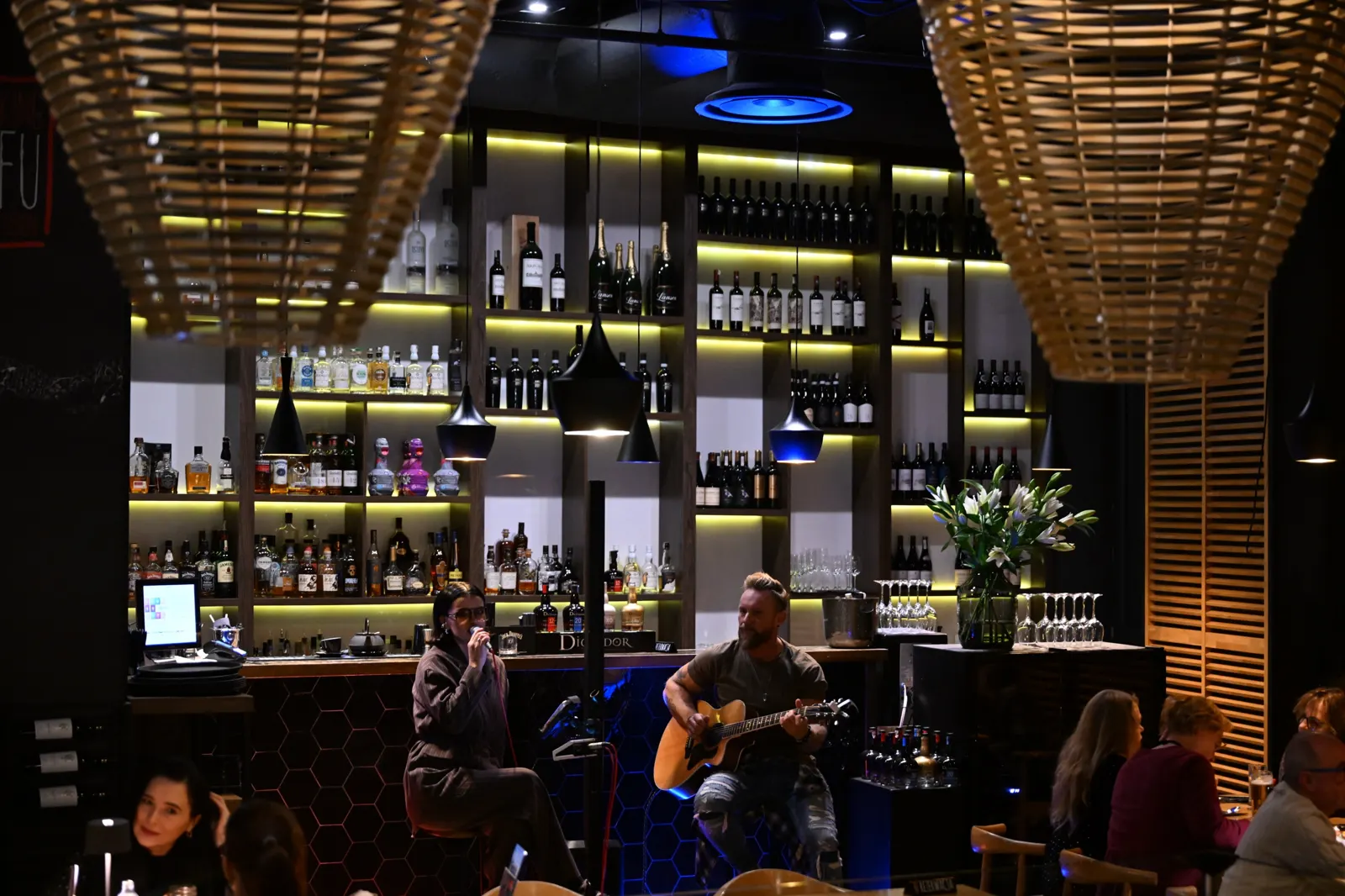 Muzyka na żywo przy barze King Fu Fusion widziana spod wiklinowych lamp – Bydgoszcz