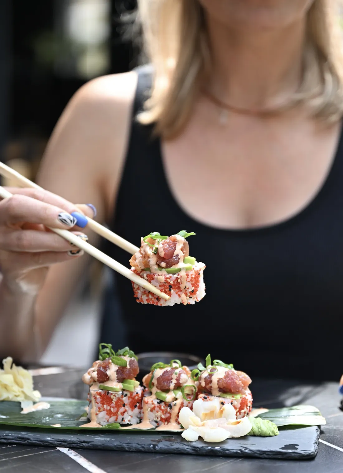 Rolka sushi z tatarem z tuńczyka i łososia, awokado, tobiko i sosem spicy mayo podnoszona pałeczkami – King Fu Fusion Bydgoszcz