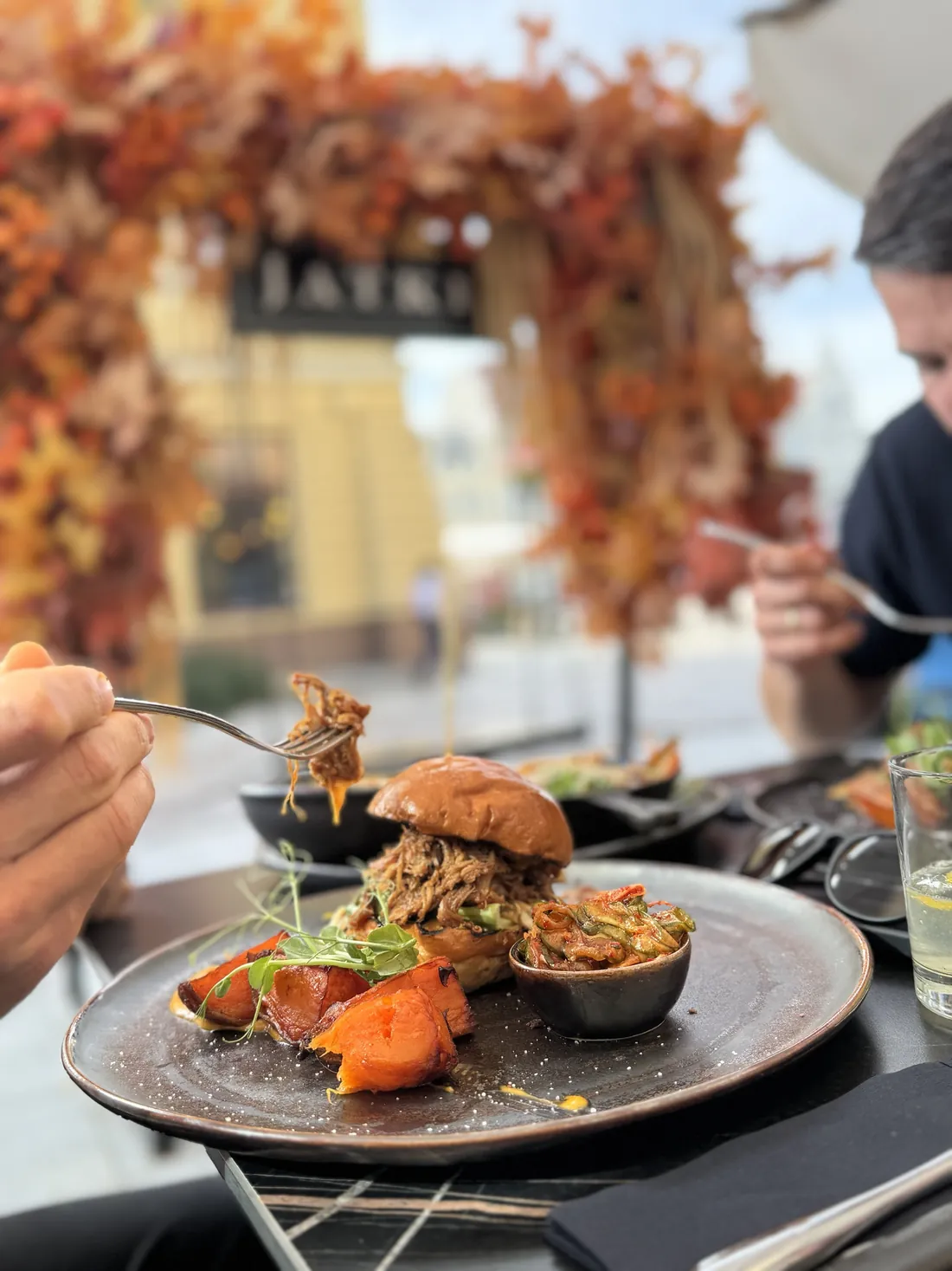 Burger z szarpaną kaczką teriyaki z frytkami z batatów i japońskimi piklami, w tle jesienne Jatki – King Fu Fusion Bydgoszcz