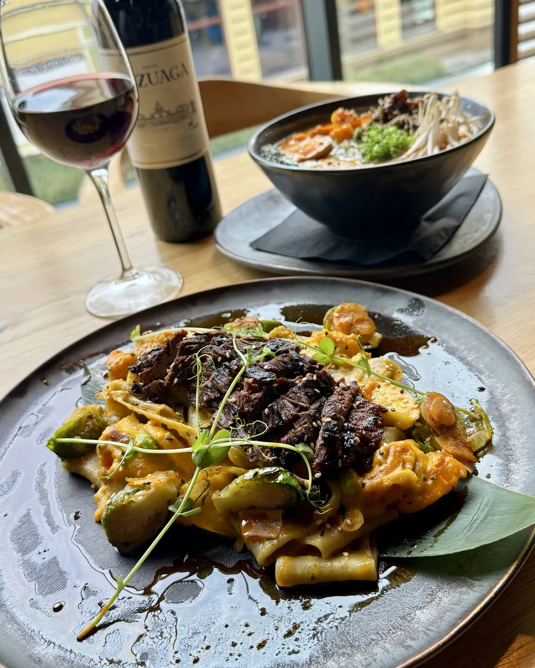 Wołowina w jesiennym umami – baweta w gochujang na makaronie biang biang z sosem z pieczonej dyni i brukselką, w tle Tantanmen z dynią – King Fu Fusion Bydgoszcz