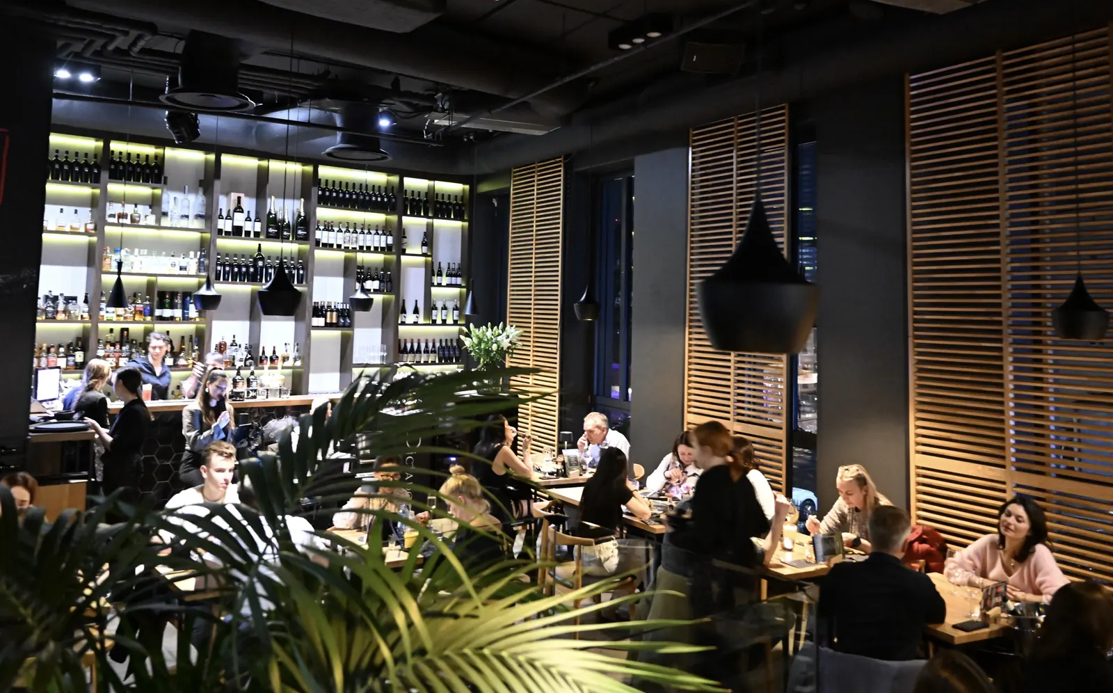Pełna sala restauracji King Fu Fusion w Bydgoszczy – podświetlony bar z winami i alkoholami, goście przy stolikach