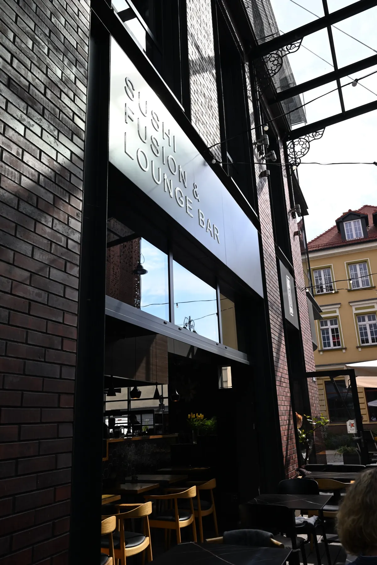 Wejście do restauracji King Fu Fusion w Jatkach w Bydgoszczy – szyld Sushi Fusion & Lounge Bar w dzień