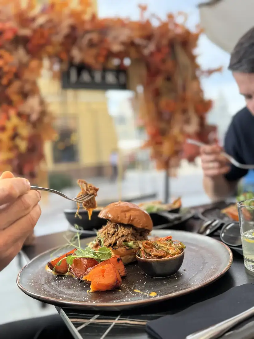 Burger z szarpaną kaczką teriyaki z frytkami z batatów i japońskimi piklami, w tle jesienne Jatki – King Fu Fusion Bydgoszcz