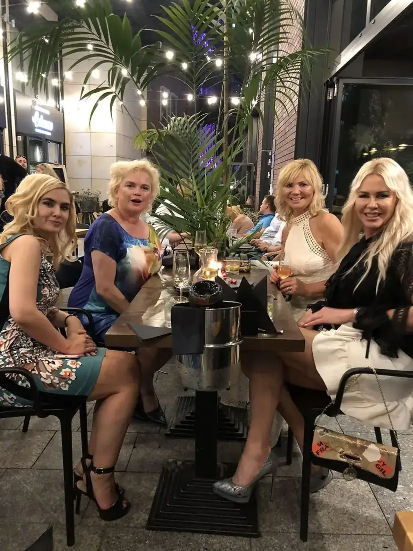 Cztery przyjaciółki przy stoliku z winem w ogródku King Fu Fusion wieczorem, wśród palm i girland świateł – Jatki, Bydgoszcz