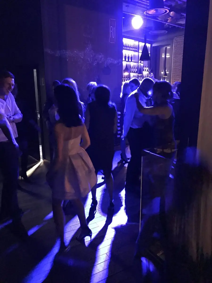 Goście tańczący na parkiecie w fioletowym świetle, w tle podświetlony bar z winami – wieczór taneczny w King Fu Fusion Bydgoszcz
