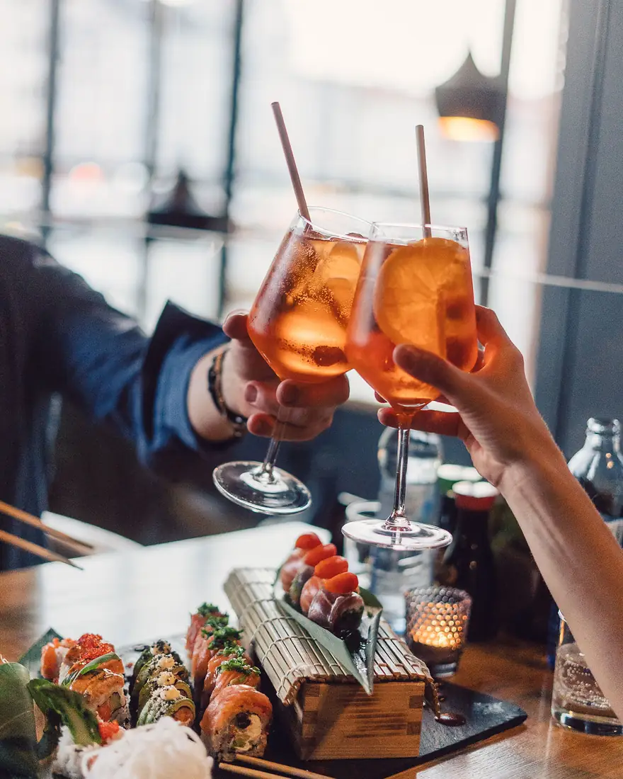 Goście wznoszą toast koktajlami spritz nad stołem z rolkami sushi – King Fu Fusion Bydgoszcz