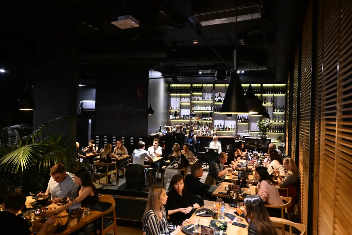Pełna sala King Fu Fusion – goście przy stołach, pianista i wokalistka przy podświetlonym lounge barze – Bydgoszcz