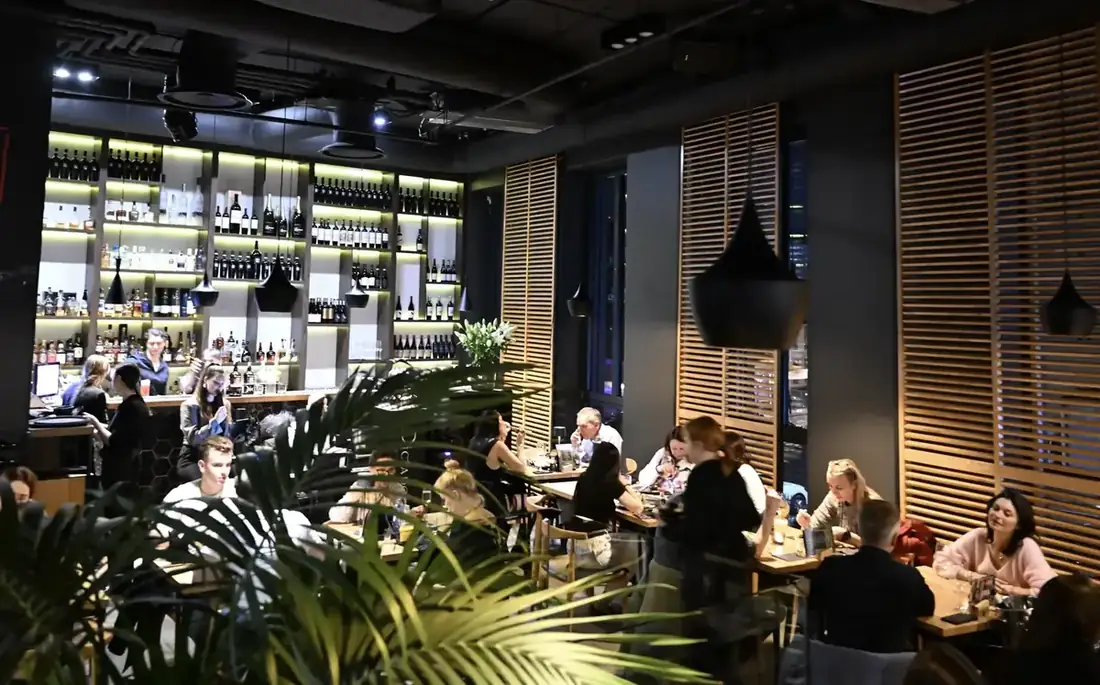 Pełna sala restauracji King Fu Fusion w Bydgoszczy – podświetlony bar z winami i alkoholami, goście przy stolikach