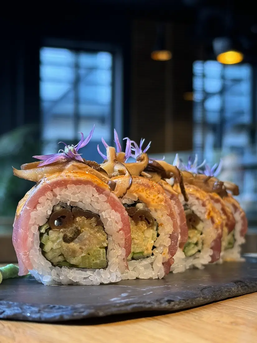 Rolka sushi w tuńczyku z grzybami shiitake i jadalnymi kwiatami na łupku – King Fu Fusion Bydgoszcz
