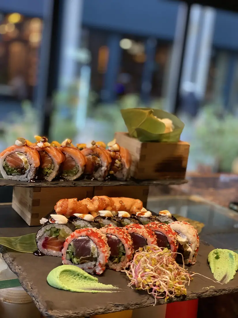 Rolki sushi z łososiem i tuńczykiem w tobiko podane na dwupoziomowym łupku z wasabi i kiełkami – King Fu Fusion Bydgoszcz