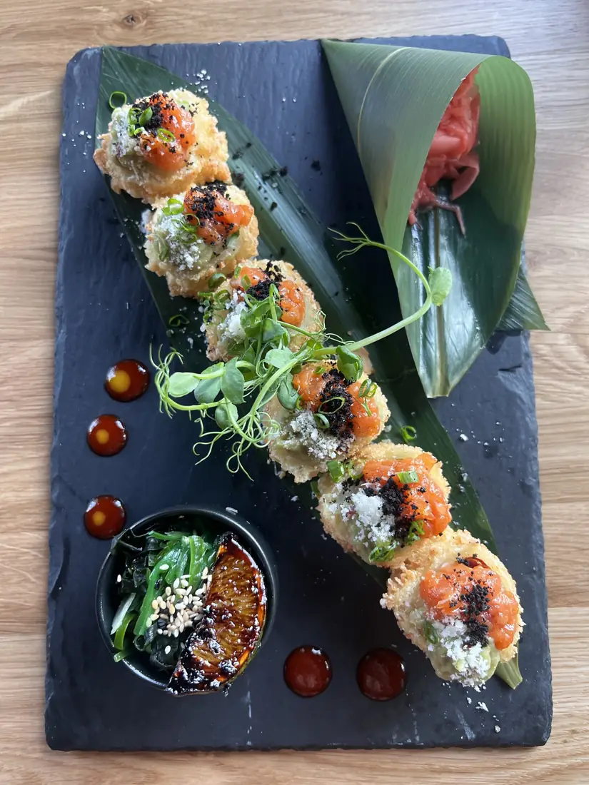 Rolki w panko z tatarem z łososia, sałatką wakame i karmelizowaną pomarańczą na łupku, widok z góry – King Fu Fusion Bydgoszcz
