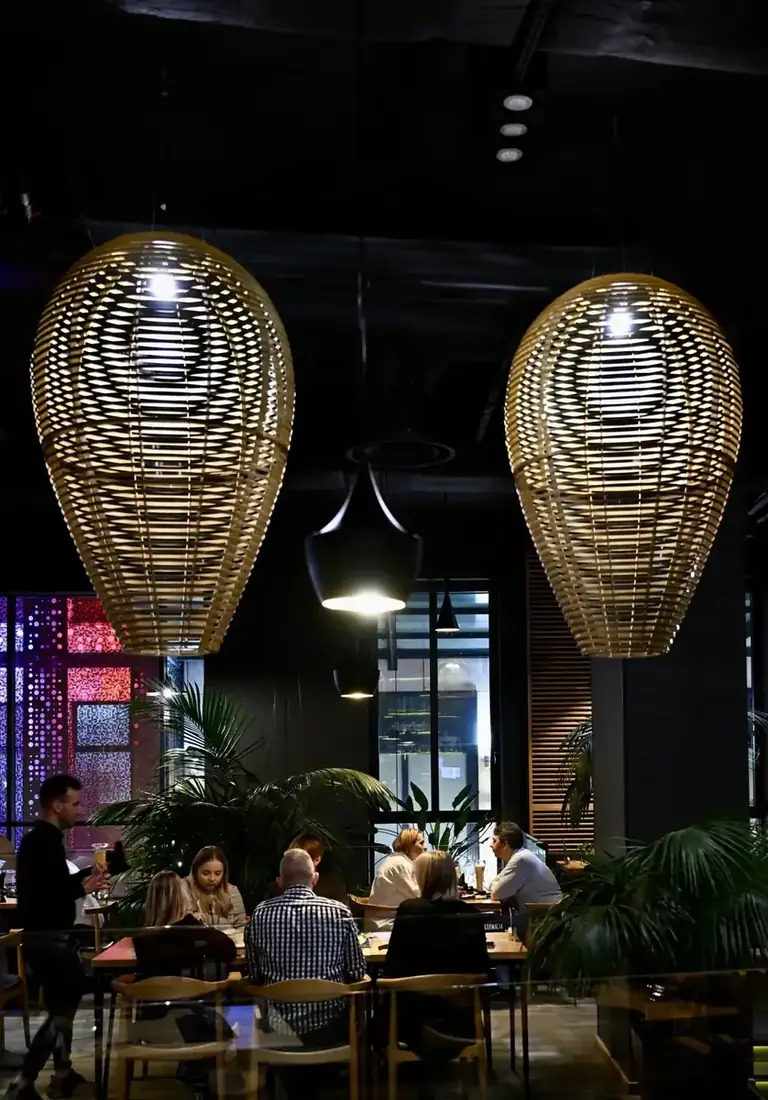 Sala King Fu Fusion w Bydgoszczy – duże wiklinowe lampy, palmy i goście przy stołach – Bydgoszcz