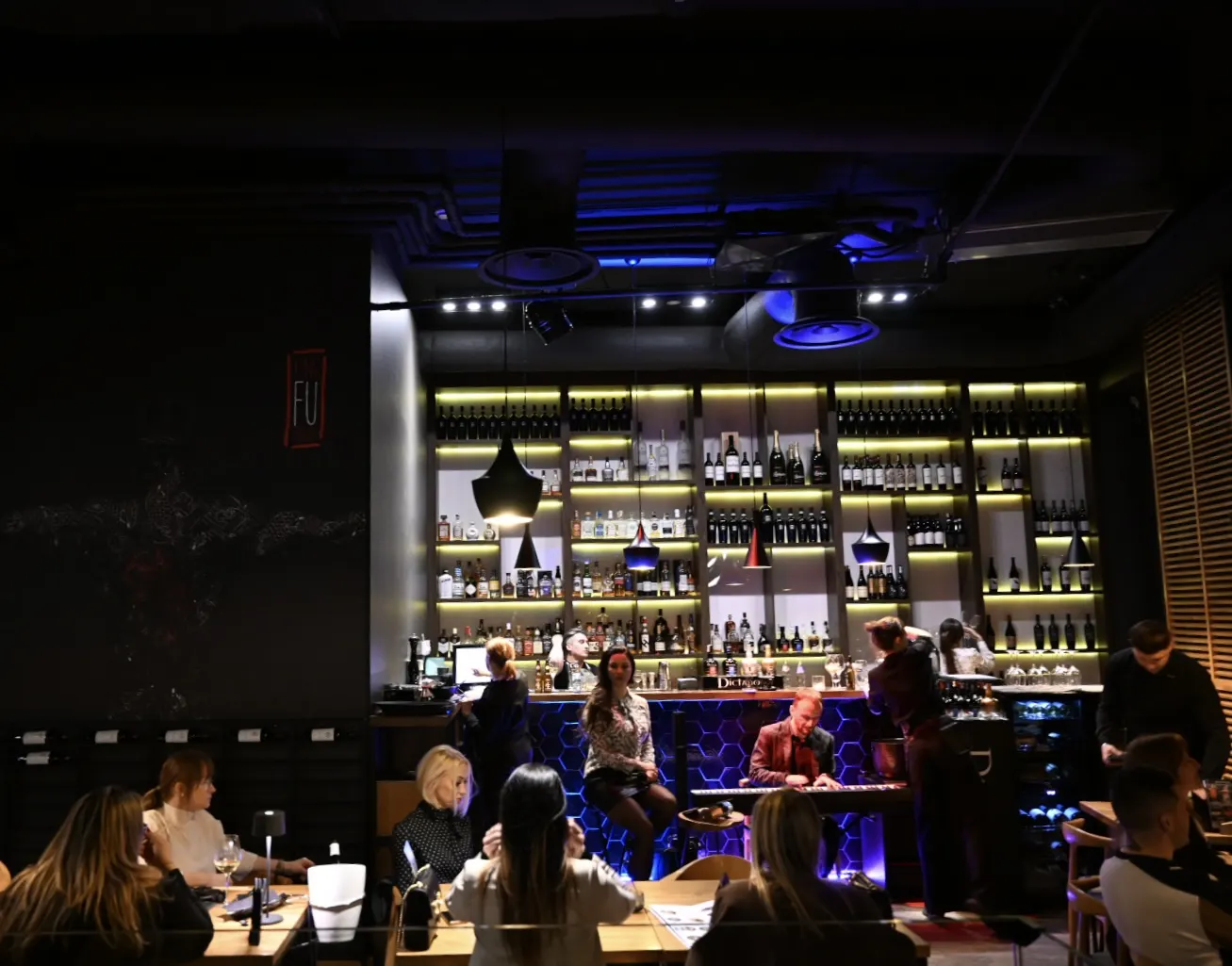 Wieczór w King Fu Fusion – pianista przy podświetlonym lounge barze, goście przy stołach – Bydgoszcz